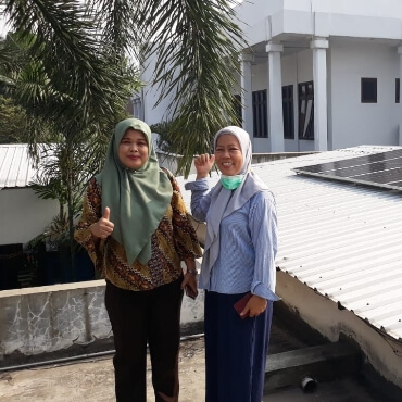 Two women in Indonesia happily giving thumbs up