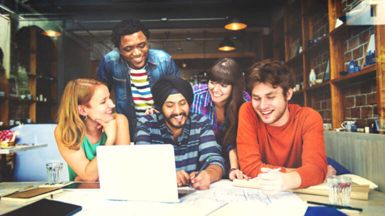 Diverse group of colleagues around a laptop screen