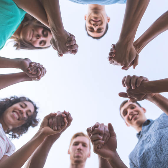 Looking up from the middle of people holding hands forming a circle